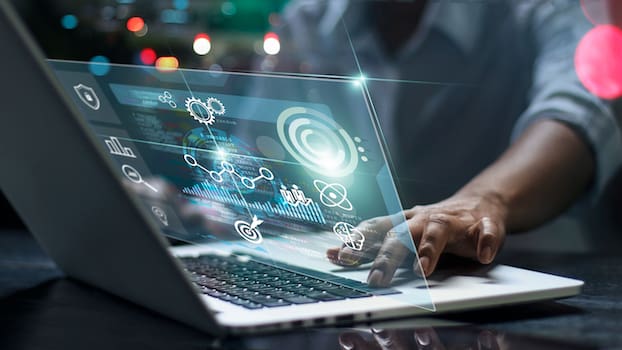 Someone working on a laptop with a growth mindset, an important way to stand out as a software engineer or developer