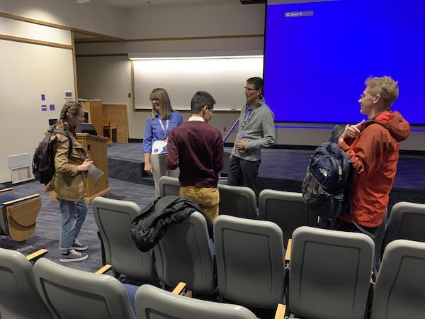 Jon Dionne and Lisa Dionne talk to students following their presentation.