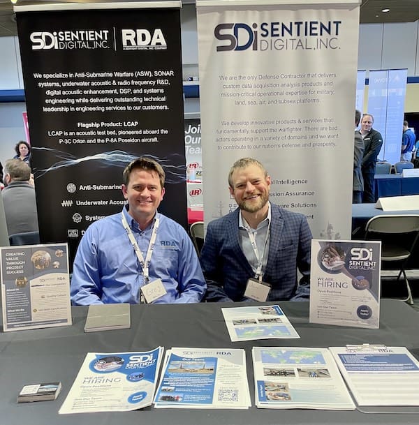 University Partnerships with Companies represented by two SDi and RDA employees at a career fair table